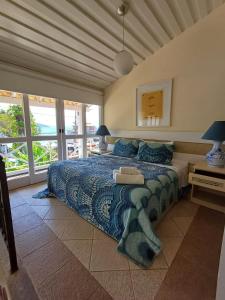 a bedroom with a bed with a blue comforter at Porto Mar de Búzios in Búzios