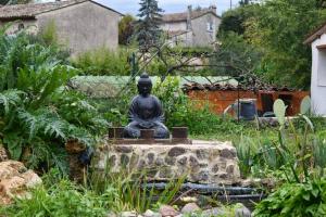 una estatua de un buddha sentado en un jardín en SUBLIME 3P de 75 M² sur MOUGINS, en Mougins