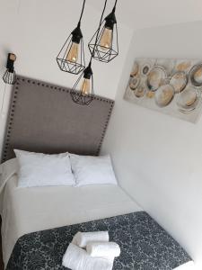 Casa Blanca في إشبيلية: غرفة نوم بسرير مع مصباحين ومنشفتين