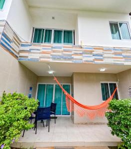 a building with a balcony with chairs and an orange rope at casa de veraneio - casa 9 - condomínio azul mar - Porto de Galinhas in Porto De Galinhas