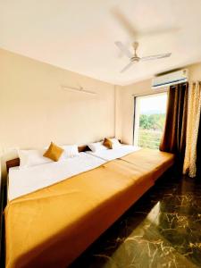 a bedroom with a large bed with a window at NB Nature Stay in Navi Mumbai