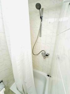 a white bathroom with a shower with a shower curtain at Central City Charm 01 in Mainz