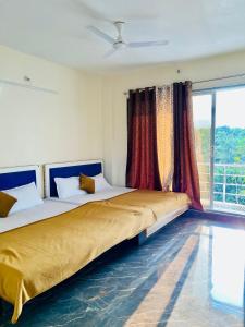 two beds in a room with a large window at NB Nature Stay in Navi Mumbai