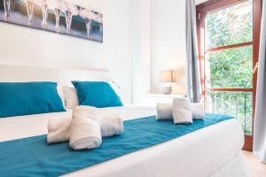 1 dormitorio con cama con almohadas y ventana en Borne Suites TI by MallorcaSuites, en Palma de Mallorca