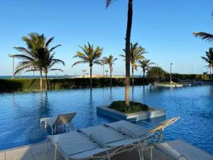 a group of chairs and palm trees in a pool at MANDARA LANAI - BL 25, APTO 202 - Aquiraz in Aquiraz +12 photos