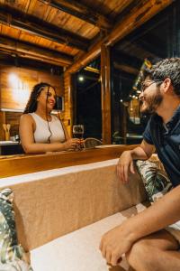 un hombre y una mujer sentados en un bar en Senz Glamping - Mindo en Mindo