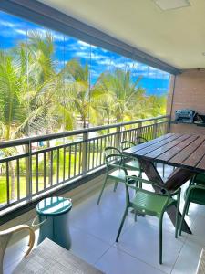 a balcony with a table and chairs and palm trees at MANDARA LANAI - BL 25, APTO 202 - Aquiraz in Aquiraz