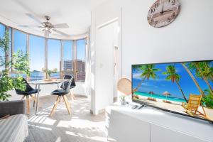 ベニドルムにあるCoblanca 5-15-4 Apartment Levante Beachのリビングルーム(大型テレビ、テーブル付)