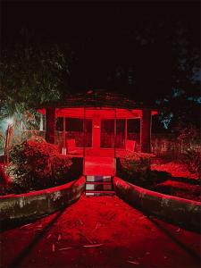 a red pavilion with chairs in a park at night at NB Nature Stay in Navi Mumbai