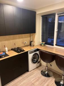 een keuken met een wasmachine en droger naast een aanrecht bij NERO apartamentai in Naujoji Akmenė