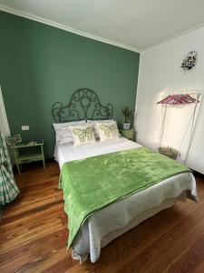 a green bedroom with a bed with a green blanket at LINO'S HOUSE in Sori