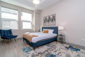 a bedroom with a bed and a blue chair at McCormick 2br/2ba KING beds suite with gym and optional parking for up to 6 guests in Chicago