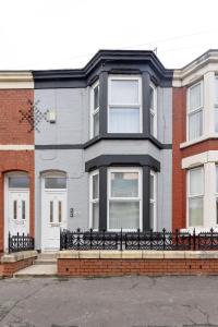 a house with a black fence in front of it at Host Liverpool - Cozy Home near Univ & Hospital,1mi to Station in Liverpool
