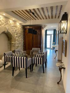 een eetkamer met stoelen en een tafel en een stenen muur bij La RENAUDIERE in LʼIsle-sur-la-Sorgue