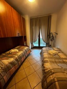 ein Hotelzimmer mit 2 Betten und einem Fenster in der Unterkunft La Corte Sul Lago casa vacanze in Pisogne