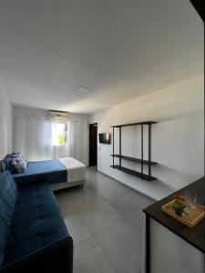 een woonkamer met een bank en een bed bij Pousada Tamatoa in Florianópolis