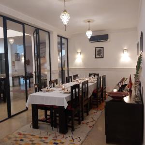 una sala da pranzo con un lungo tavolo e sedie di RIAD ANYSSA a Marrakech