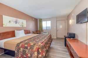 a hotel room with a bed and a flat screen tv at The Starwood Inn in Bohemia