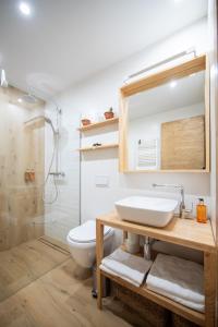 a bathroom with a sink and a toilet and a shower at La Râu 663A - Riverside Mountain Chalet with Outdoor Jacuzzi in Porumbacu de Sus +17 photos