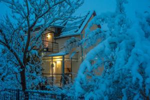 una casa cubierta de nieve por la noche en MaMaison en Veresegyház