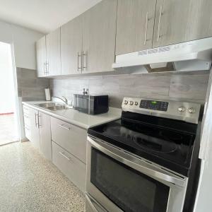 a kitchen with a stove and a sink at Beautiful Caribbean Waters - 7 Seas Beach, El Yunque, Icacos Island in Fajardo