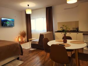 a living room with a dining table and a kitchen at Garden City Studio in Sibiu