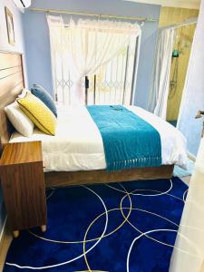 a bedroom with a large bed with a blue carpet at Monaco villa Gaborone in Gaborone