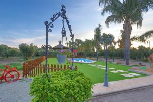 een park met een schommel en een tuin met een zwembad bij Casa Rural en el entorno de Doñana in Hinojos