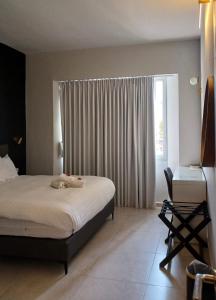 a bedroom with a bed and a desk and a window at White Moon Inn in Jerusalem