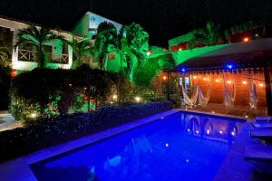 a swimming pool in front of a house at night at Pousada Oasis Paracuru in Paracuru