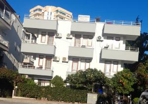 un edificio bianco con balconi sul lato di Begumhan Pansiyon a Antalya (Adalia)