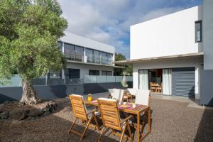 a patio with a table and chairs in front of a house at Villa Girassol by An Island Apart in Porto Santo