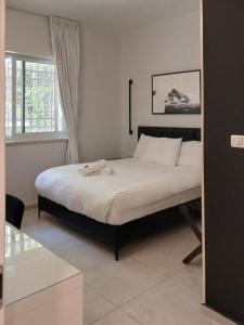1 dormitorio con 1 cama grande con sábanas blancas en White Moon Inn, en Jerusalén