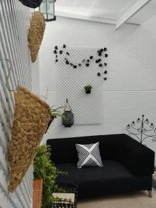a living room with a black couch and a wall at La casita del vino in Socuéllamos
