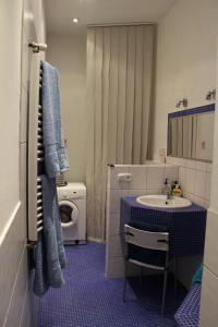 a bathroom with a sink and a washing machine at Kiona Apartment in Budapest