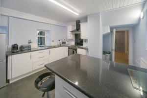 cocina con armarios blancos y encimera negra en Constancevilla B9 - Grampian Lettings Ltd en Aberdeen