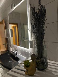 eine Blumenvase auf einem Waschbecken im Bad in der Unterkunft Rheinview Sunset Apartment Urbar in Urbar
