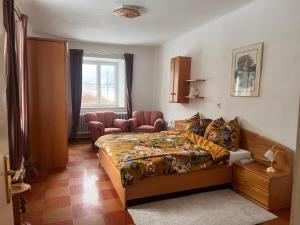 1 dormitorio con 1 cama, 1 silla y 1 ventana en Hubenbauer - Bauernhaus mit Garten und Parkplatz en Unzmarkt