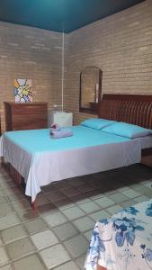 sypialnia z dużym łóżkiem z niebieskimi poduszkami w obiekcie Quartos aconchegantes na praia do francês w mieście Marechal Deodoro