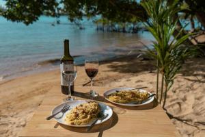 uma mesa com dois pratos de comida e dois copos de vinho em Coral Bay Resort em Koh Ta kiev