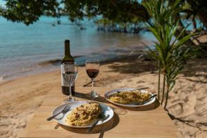 a table with two plates of food and two glasses of wine at Koh Ta Kiev Island Resort in Koh Ta kiev Island