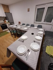 巴尼亞盧卡的住宿－VIKENDICA - PRENOĆIŠTE Banjaluka，桌子上摆着盘子和餐具