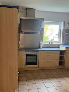a kitchen with a stove and a window at Rheinview Sunset Apartment Urbar in Urbar