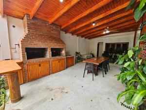 sala de estar amplia con mesa y pared de ladrillo en Charaí Lodge en Puerto Iguazú