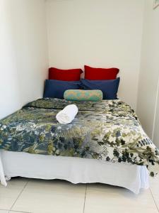 a bedroom with a bed with blue and red pillows at Mila Lodge 2 in Cape Town