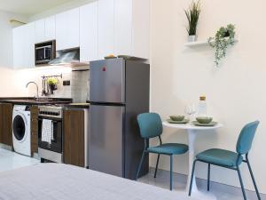 a kitchen with a refrigerator and a table with chairs at Elite LUX Holiday Homes - Modern Studio in Arjan, Dubai in Dubai