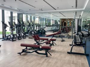 a gym with a lot of treadmills and machines at Elite LUX Holiday Homes - Modern Studio in Arjan, Dubai in Dubai