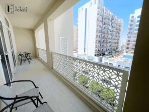 - Balcón con mesa y sillas en un edificio en Elite LUX Holiday Homes - Two Bedroom Apartment Metro Nearby in Al Furjan, Dubai en Dubái