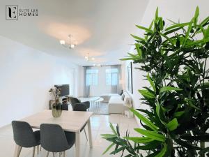 Elite LUX Holiday Homes - Two Bedroom Apartment Metro Nearby in Al Furjan, Dubai في دبي: غرفة معيشة مع طاولة ومصنع