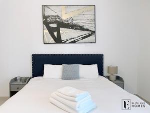 a bedroom with a bed with towels on it at Elite LUX Holiday Homes - Two Bedroom Apartment Metro Nearby in Al Furjan, Dubai in Dubai